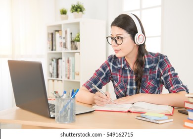 Student Learning On Line With Headphones And Laptop. Mixed Race Asian Chinese Model.