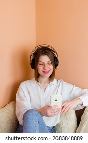 Student Learning In Online Library, Distance Education, E-learning. Girl Wearing Headphones Studying Foreign Language, Woman Taking Classes Looking At Smart Phone Screen. Vertical Photo