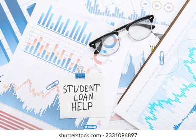 Student loan help note on financial charts with eyeglasses and paperclips, education debt management and assistance