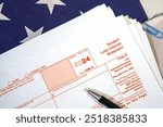 Student loan interest statement form 1098-E with pen on the paper. American student loan form backdrop with flag