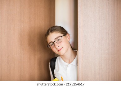 Student Looks Into Classroom. Back To School. Portrait Of Caucasian Teenager Girl On Background Of Door With Copy Space.