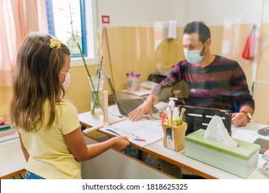 Student With A Mask Handing Over Homework To The Teacher Through A Screen