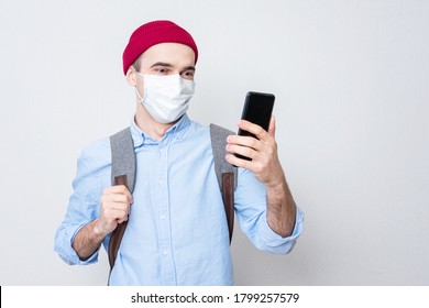 Student In A Medical Mask Is Using Phone, White Background, Portrait