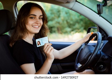 Student in a modern car showing driving licence - Shutterstock ID 1492730927