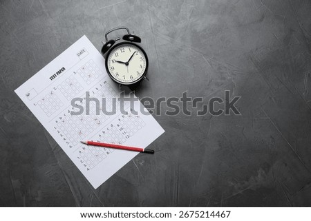 Student passing exam. Answer sheet, alarm clock and pencil on gray textured table, flat lay. Space for text