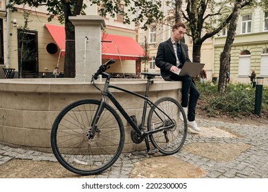 Student With Pc And Bicycle Outdoor - Freelance Young Guy Work With Computer Outside. Concept Of Modern Green Lifestyle