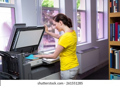 Student photocopying her book in the library at the university - Powered by Shutterstock