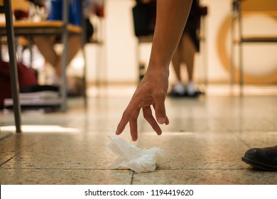 A Student Picking Up A Waste Tissue Paper Inside A Classroom