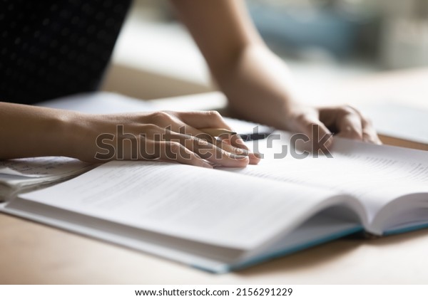 Student preparing for
college test, exam, reading book, studying textbook, writing notes,
making summary for class report. Learning workplace table, hands
with pencil close up
