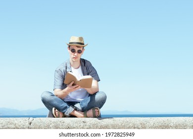 Student Reading A Book In Summer. Studying Outdoors Concept.