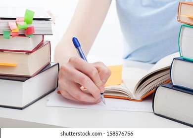 Student Reading A Book And Writing The Notes