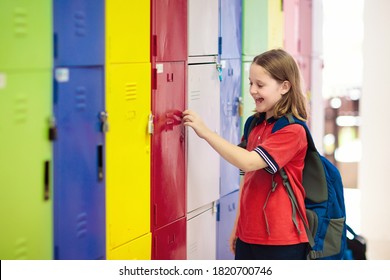 Student In School At Locker. Kids Study. Little Girl In Uniform Holding Padlock Key In Preschool Hall. Child With Backpack And Books.