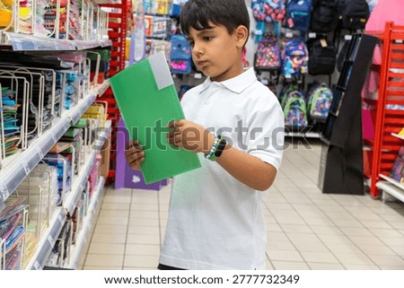 student in school uniform choosing school folder on the shopping mall