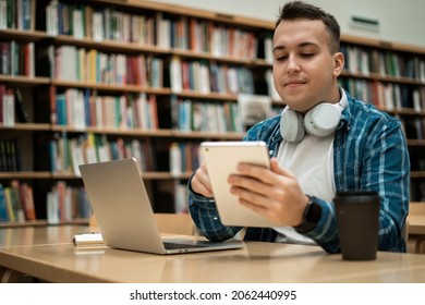 Student smart studying online at college. Reads information and an e-book on a tablet. A man in a lesson at the university. - Shutterstock ID 2062440995