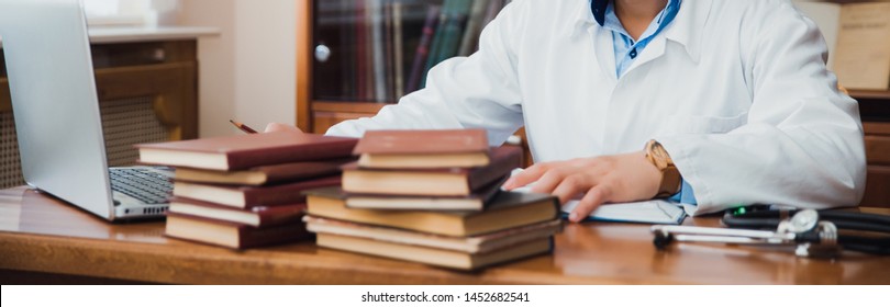 Student study in the university library.She using laptop and learning online. Concept of distance education and entrance exams in a medical college.