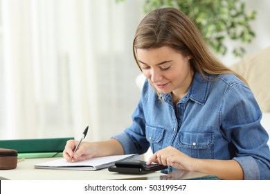 Student Studying Calculating With A Calculator And Handwriting Notes Siting On The Floor In The Living Room At Home