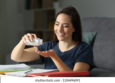 Student Studying Late Hours Taking Virtamin Supplement Pills At Home