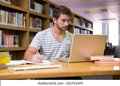 Student Studying In The Library With Laptop At The University