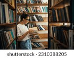 A student stuying and reading books in a public library of university.