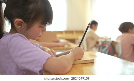The student is taking notes while being taught by the teacher in the classroom, demonstrating a positive and attentive learning atmosphere in an international school