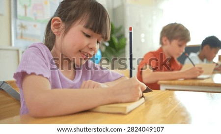 The student is taking notes while being taught by the teacher in the classroom, demonstrating a positive and attentive learning atmosphere in an international school