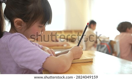 The student is taking notes while being taught by the teacher in the classroom, demonstrating a positive and attentive learning atmosphere in an international school