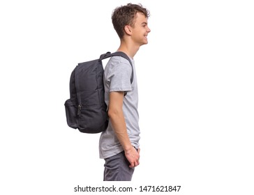 Student Teen Boy With Backpack - Side View. Portrait Of Cute Smiling Schoolboy With Hands In Pockets, Isolated On White Background. Happy Child Back To School - Profile.