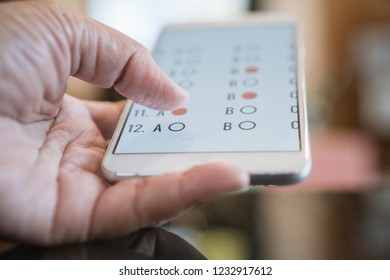 Student testing E-learning exam on tablet computer with multiple choice questions by finger clicking. Concept Educational technology use physical hardware internet for distant online learning 