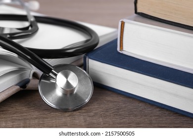 Student textbooks and stethoscope on wooden table, closeup. Medical education - Shutterstock ID 2157500505