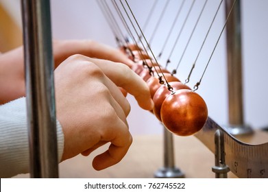 Student Touch Newton Cradle In Laboratory. Physics Experiment Concept.