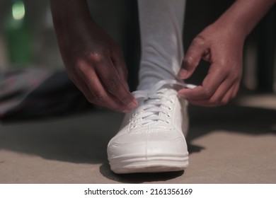 A Student Tying Shoelaces Closeup View