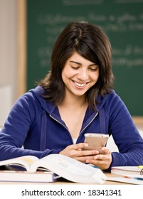 Student Using Calculator While Doing Homework In School Classroom