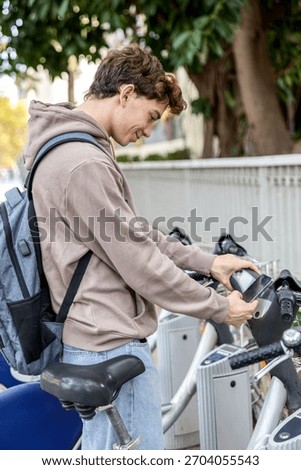 Student using phone to unlock shared bike at rental station
