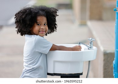 Student Washing Hand From Faucet Running Water At Outdoor To Protect Coronavirus Epidemic.