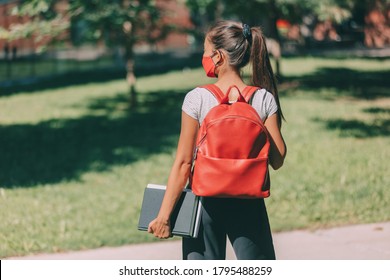 Student Wearing Mask On Campus Going Back To School. Girl University Student Wearing Protective Face Covering Walking With Books And Backpack. Young Woman At College.