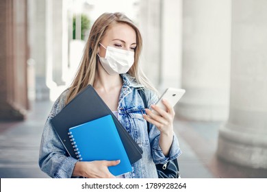 Student Women Wears A Protective Antiviral Face Mask Reads Messages On A Mobile Phone During The Coronavirus Quarantine  