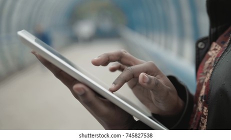 Student working with her tablet in the street, city street, subway