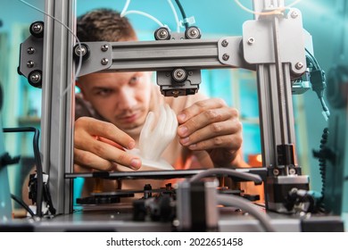 student in the workshop examines the detail printed on a 3D printer. High quality photo