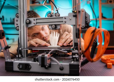 student in the workshop examines the detail printed on a 3D printer.focus on product. High quality photo - Powered by Shutterstock