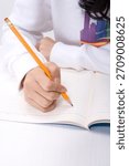 Student writes notes with a pencil in a notebook during a study session