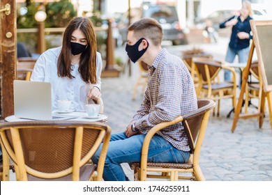 Student youth hipster man and young woman in facial masks drinking coffee at an outdoor bar cafe or restaurant. New normal concept reopening after quarantine concept. - Powered by Shutterstock