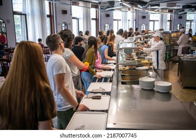 Students Being Served Meal In School Canteen. Lunch Break. Education People And Student In Line Wait For Food Meals And Eating Food In Cafeteria. Belgrade, Serbia 17.05.2022