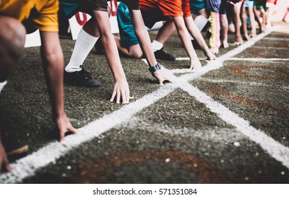 Students boy get set to leaving the starting for running competition boy at school sports day. School sports day concept. - Shutterstock ID 571351084