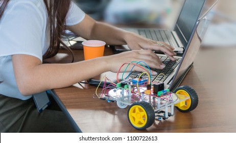 Students code a metal car robot and an electronic board. Robotics and electronics. Laboratory. Mathematics, engineering, science, technology, computer code. STEM education. 