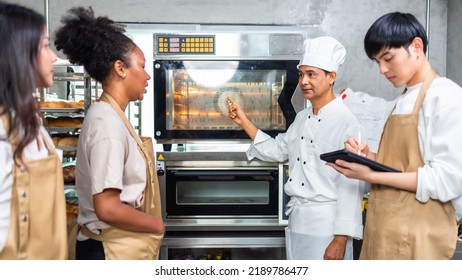 Students In Cookery Class Mixing Ingredients For Recipe In Kitchen.Male And Female Young  Students With Chef Teacher Preparing Ingredients For Dish In Kitchen Cookery Class.