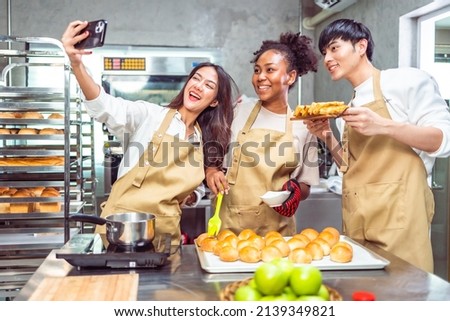 Students In Cookery Class Mixing Ingredients For Recipe In Kitchen.Group of young people taking selfie during cooking classes.