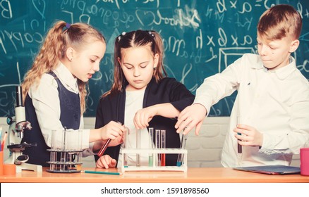 students doing biology experiments with microscope in lab. Little kids learning chemistry. Looking at the future of science. Chemistry education. Happy children. Chemistry lesson. Chemistry equipment.
