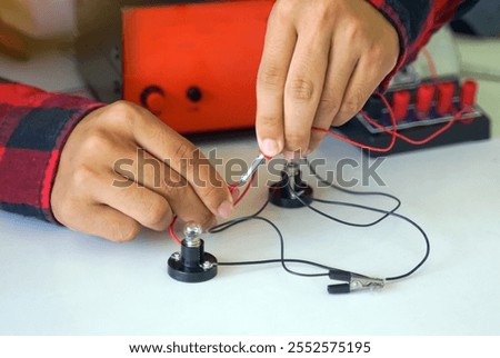Students experiment with simple electronic circuits. Principles of traffic light circuits. Soft and selective focus.                               