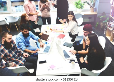 Students of Graduate Business School are preparing for delivery of the management project and enterprise promotion in social networks. Creative designers working on laptops around a table of coworking - Powered by Shutterstock