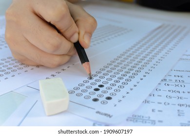 Students Hand Holding Pencil Writing Selected Choice On Answer Sheets And Mathematics Question Sheets. Students Testing Doing Examination. School Exam